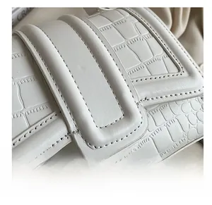 Gros plan du sac en cuir crème à motif crocodile avec coutures précises et texture