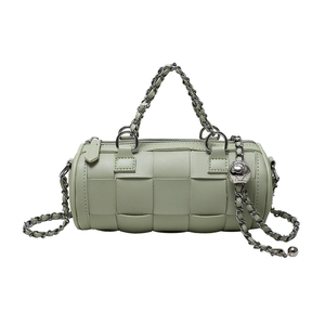 Mint green cylinder shoulder bag featuring wide woven leather and silver chain strap