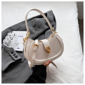 Detail of cream crescent bag featuring a golden circular buckle and smooth PU texture