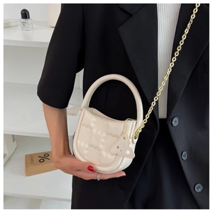 Detail of cream white mini crossbody bag with cloud texture and gold chain strap