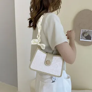 Chic cream white underarm bag with embossed cartoon patterns and silk scarf handle