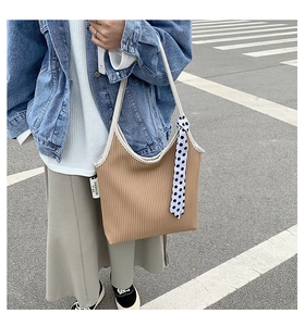 Close-up of pleated texture on a brown shoulder bag with a polka dot scarf detail