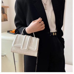 Détail du sac à main blanc gaufré crocodile avec chaîne argentée et poignée chic