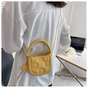 Yellow waffle textured crossbody bag with gold chain strap and cheese pendant detail
