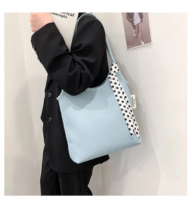 Detail of light blue pleated shoulder bag with polka dot scarf and fashion tag detail