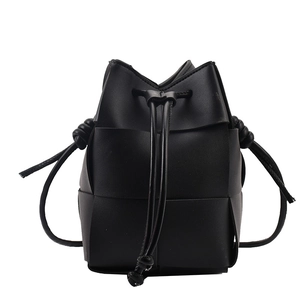 Minimalist black hand-woven leather bucket bag with crossbody strap and drawstring closure