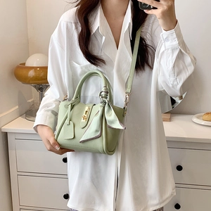 Elegante borsa a mano in pelle verde chiaro con chiusura dorata e foulard di seta