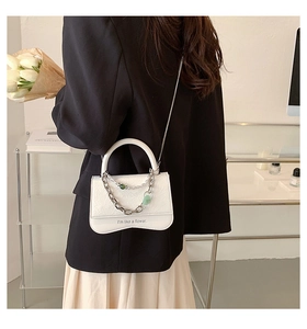 Mini white leather crossbody bag with silver chain and unique wavy base detail
