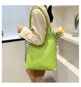 Detail of green corduroy tote bag with side label showing texture and fashion style