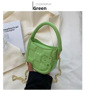 Close-up of green PU leather mini bag with puffy geometric texture and chain strap