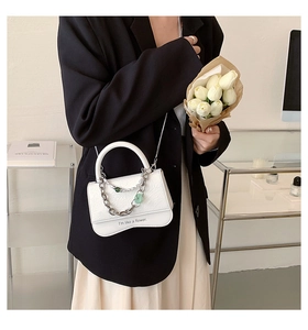 Close-up of white crossbody bag with wavy bottom and floral quote lettering detail