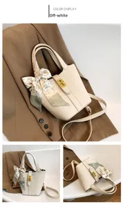Dettaglio della borsa a secchiello bianco crema in pelle granata con manico foulard