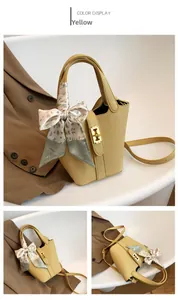 Dettaglio della borsa a secchiello gialla in pelle con foulard floreale e chiusura dorata