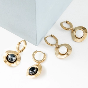 Detail view of 18k gold plated earrings featuring radial textures and inlaid natural stones