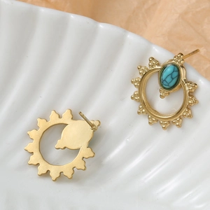 Bohemian gold sunburst earrings with natural turquoise stones on a shell tray
