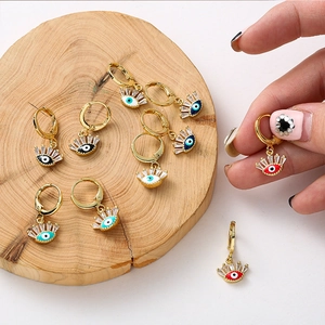 Détail de créoles œil porte-bonheur colorées avec incrustation de zircon et finition or