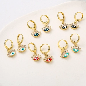Détail de boucles d'oreilles œil de démon avec émail coloré et zircon sur plateau