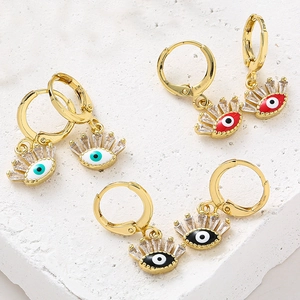Détail des boucles d'oreilles créoles oeil maléfique dorées avec accents zircons colorés