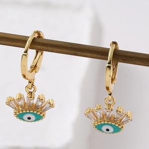 Détail de boucles d'oreilles dorées Evil Eye avec émail turquoise et zircons brillants