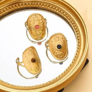 Detail of vintage shield rings with inset gemstones and gold textured relief