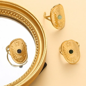Macro detail of vintage gold shield rings with natural stone inlay and sunburst texture