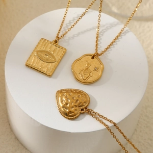 Goldene Herzanhänger und Bienenrelief-Halsketten aus Edelstahl auf weißem Ständer
