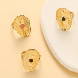 Vintage gold shield ring with sunburst embossing and inlaid stones in a three-piece set