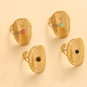 Detail of four vintage gold shield rings featuring colorful natural stones and ornate textures