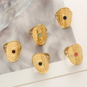 Close-up of vintage shield rings with colorful stones and sunray texture in gold finish