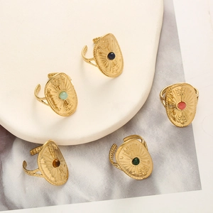 Detail of five-piece vintage shield ring set with colorful stones on ceramic tray