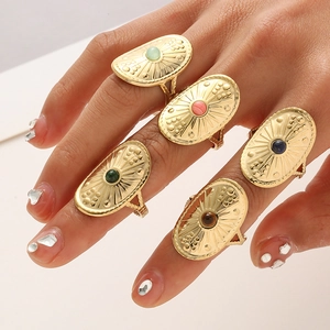 Detail of vintage gold shield rings set with colorful oval stones and sunburst texture