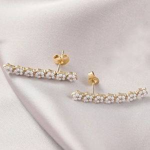 Détails de boucles d'oreilles pendantes françaises avec perles blanches et base dorée