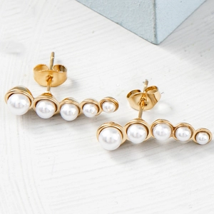 Vue détaillée de boucles d'oreilles pendantes en perles dorées de style français chic