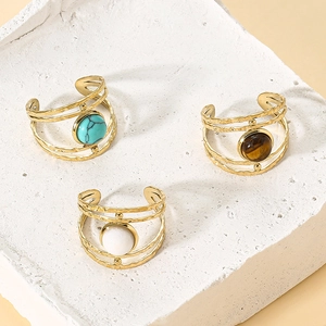 Detail of three-layer hammered gold rings featuring turquoise, tiger eye and marble stones