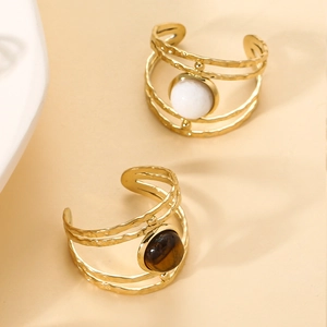 Detailed view of gold multi-layer hollow rings with white and brown gemstone inlays
