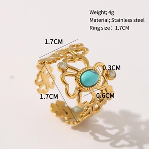 Detail of gold floral cut-out ring with turquoise stone and white zircons