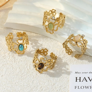Golden flower open ring set with opal and crystal details on stone display