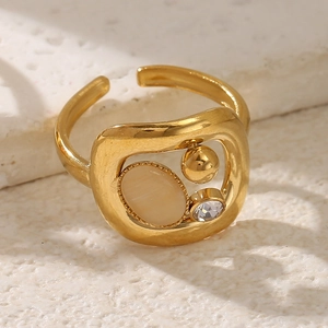 Détail d'une bague vintage dorée avec œil de chat et zircone sur une texture de pierre