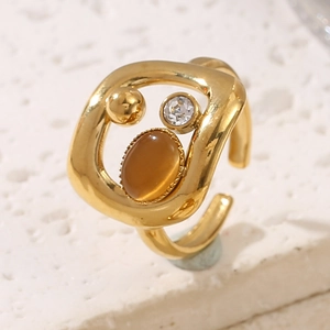 Détail macro d'une bague dorée ornée d'une pierre ambre et de strass brillants