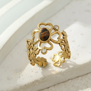 Macro detail of gold flower open ring with tiger eye stone and crystal accents