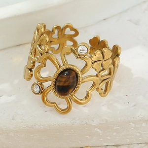 Macro view of gold flower ring with cat eye stone inlay and hollow clover design