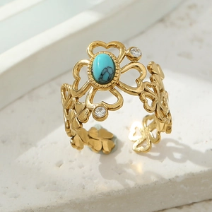 Detailed shot of vintage gold cutout heart ring with turquoise stone and zircon accents