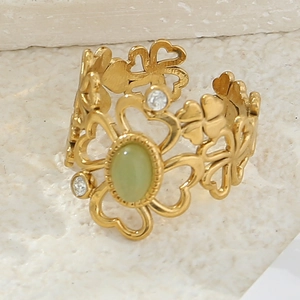 Macro shot of gold floral ring with green cat eye stone and small diamonds on stone base