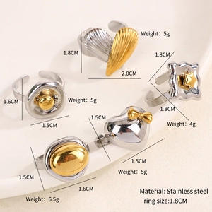 Close-up of assorted stainless steel rings with mixed gold and silver tones in a tray