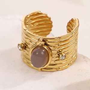 Makro-Detail eines goldenen Vintage-Rings mit grauem Edelstein und funkelnden Zirkoniasteinen