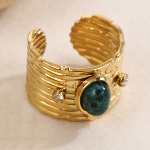 Makroaufnahme: Vintage Goldring mit Wellenstruktur, grünem Stein und Zirkonia