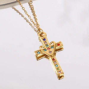 Dettaglio della collana con croce dorata con cuore e strass multicolori scintillanti