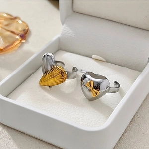 Detail shot of two adjustable heart rings with two-tone finish and golden bow detail