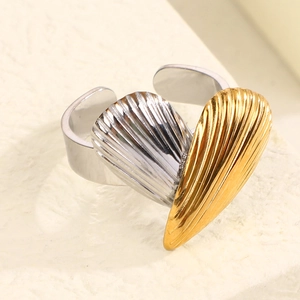 Macro shot of two-tone gold and silver heart-shaped ring with textured vertical stripes