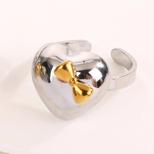 Detail view of heart-shaped adjustable ring with golden 3D bow accent and metallic finish
